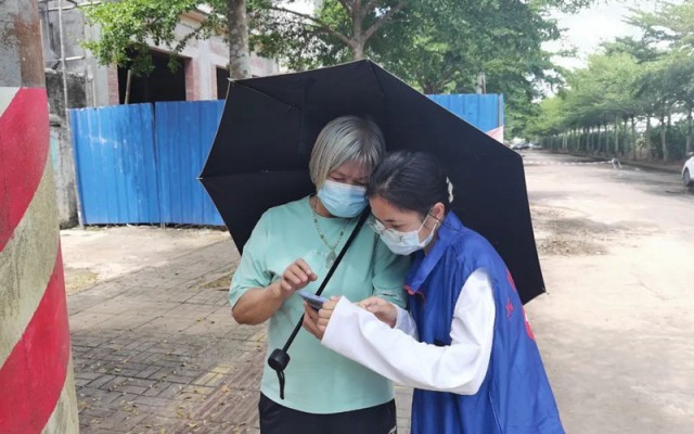 澄迈县志愿者帮助群众打开健康码。