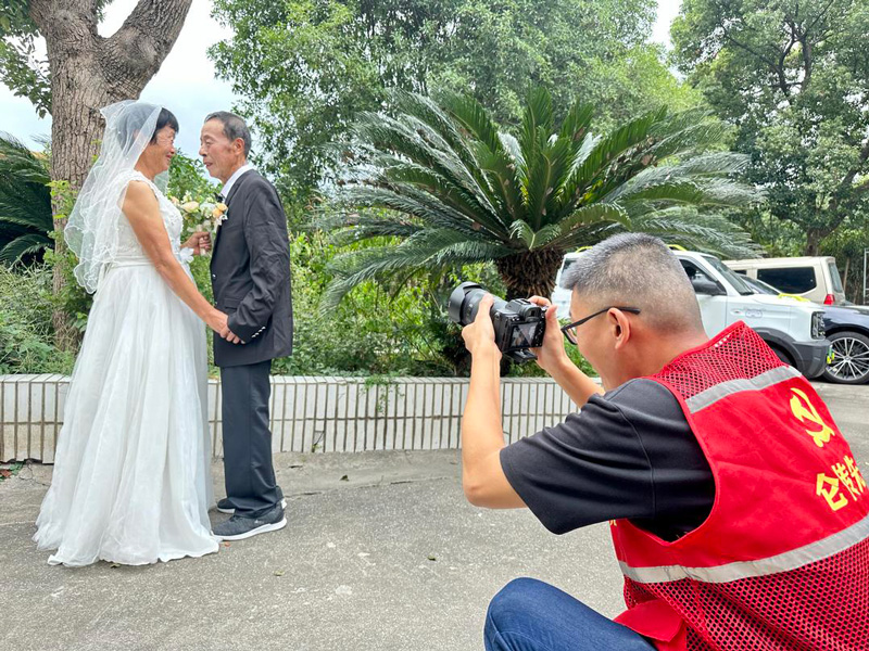 志愿者为金婚老人拍摄。刘唯摄