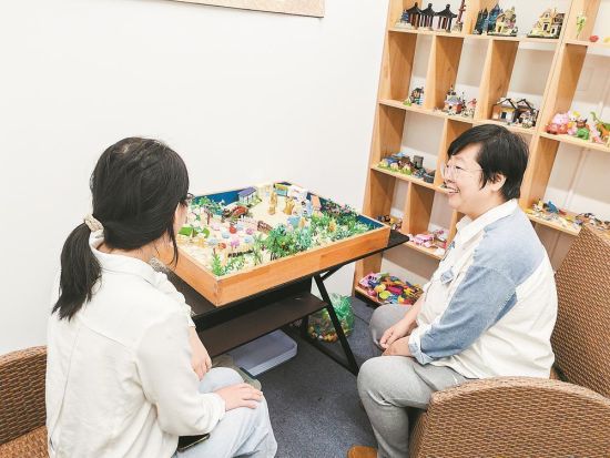 郑迎春为受助者开展沙盘游戏疗法。(受访者供图)