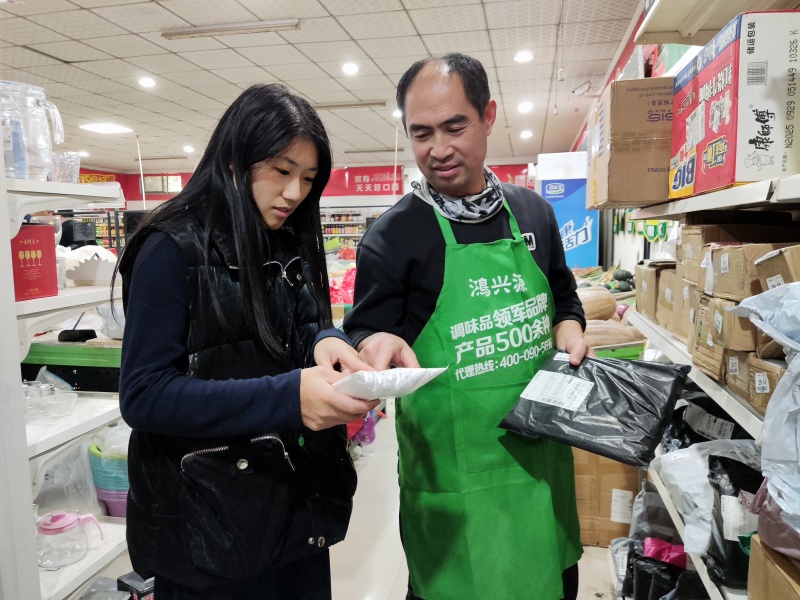 图为村民在建芳超市领取快递
